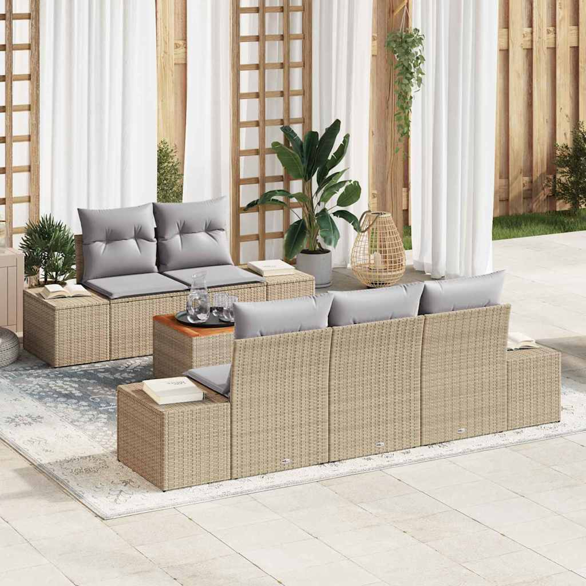 Rattan-Gartenmöbel-Set. Enthält ein Loveseat, ein Sofa und einen Couchtisch. Kissen sind grau. Weiße Vorhänge und Pflanzen im Hintergrund.