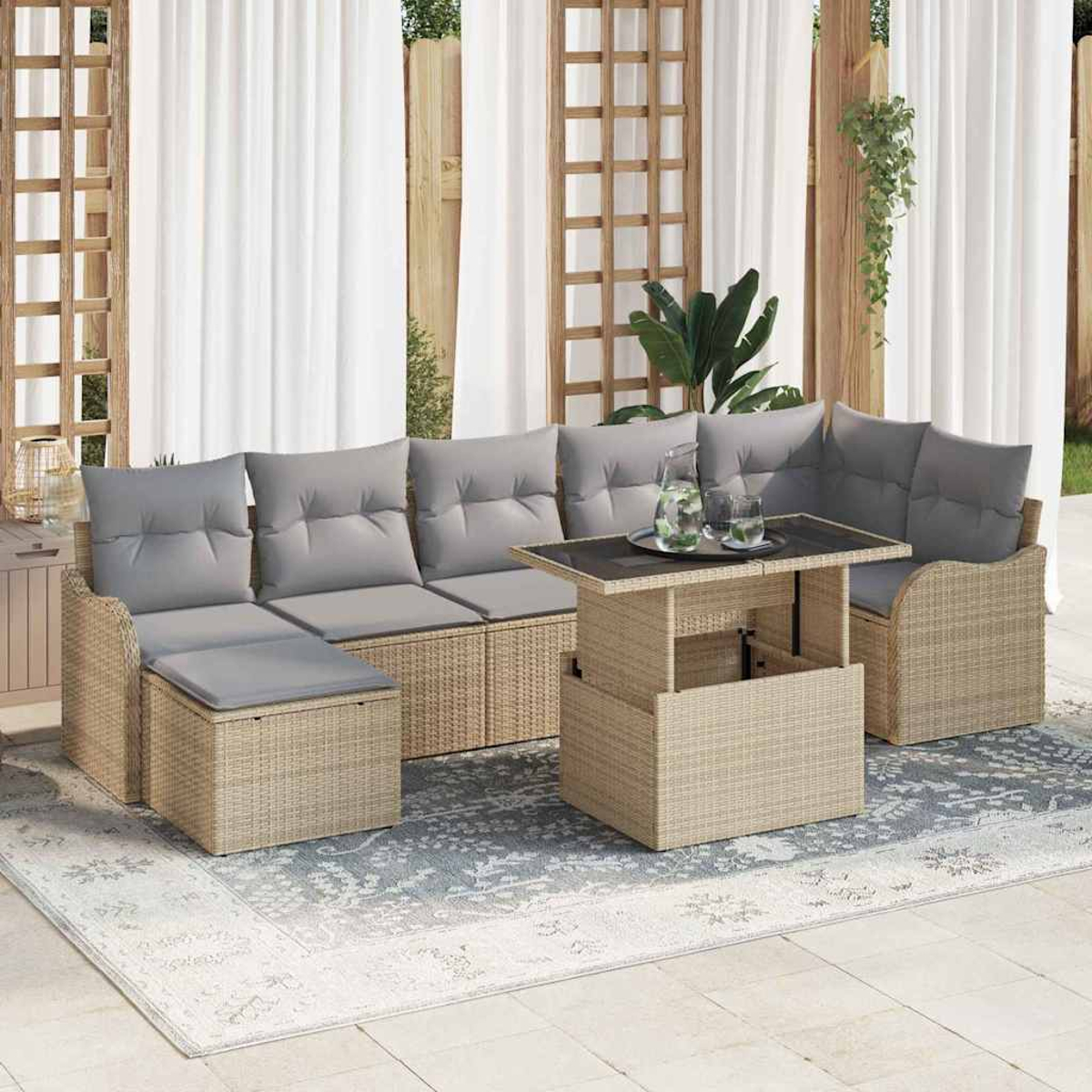 Gartenmöbel-Set. Beige Korbsessel mit grauen Kissen, Tisch mit Hubtisch und Teppich. Weiße Vorhänge und Holzgitter im Hintergrund.