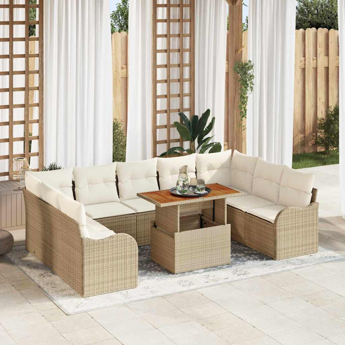 Juego de asientos para exteriores con cojines beige y marcos de mimbre. Una mesa de madera con bebidas en el centro. Cortinas blancas al fondo.