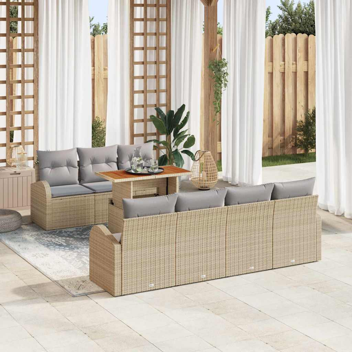 Terrassenszene mit Korbmöbeln, grauen Kissen, einem kleinen Tisch und weißen Vorhängen. Ein Holzzaun und Pflanzen befinden sich im Hintergrund.