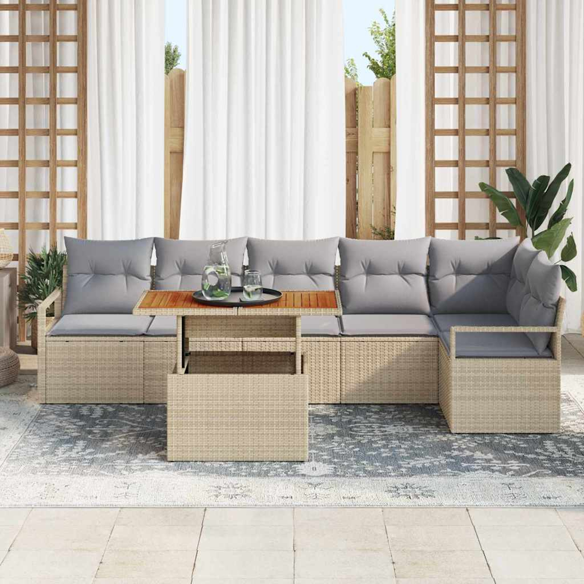 Outdoor-Ecksofa mit grauen Kissen, Holztisch mit Getränken und gemustertem Teppich. Weiße Vorhänge und Grün im Hintergrund.