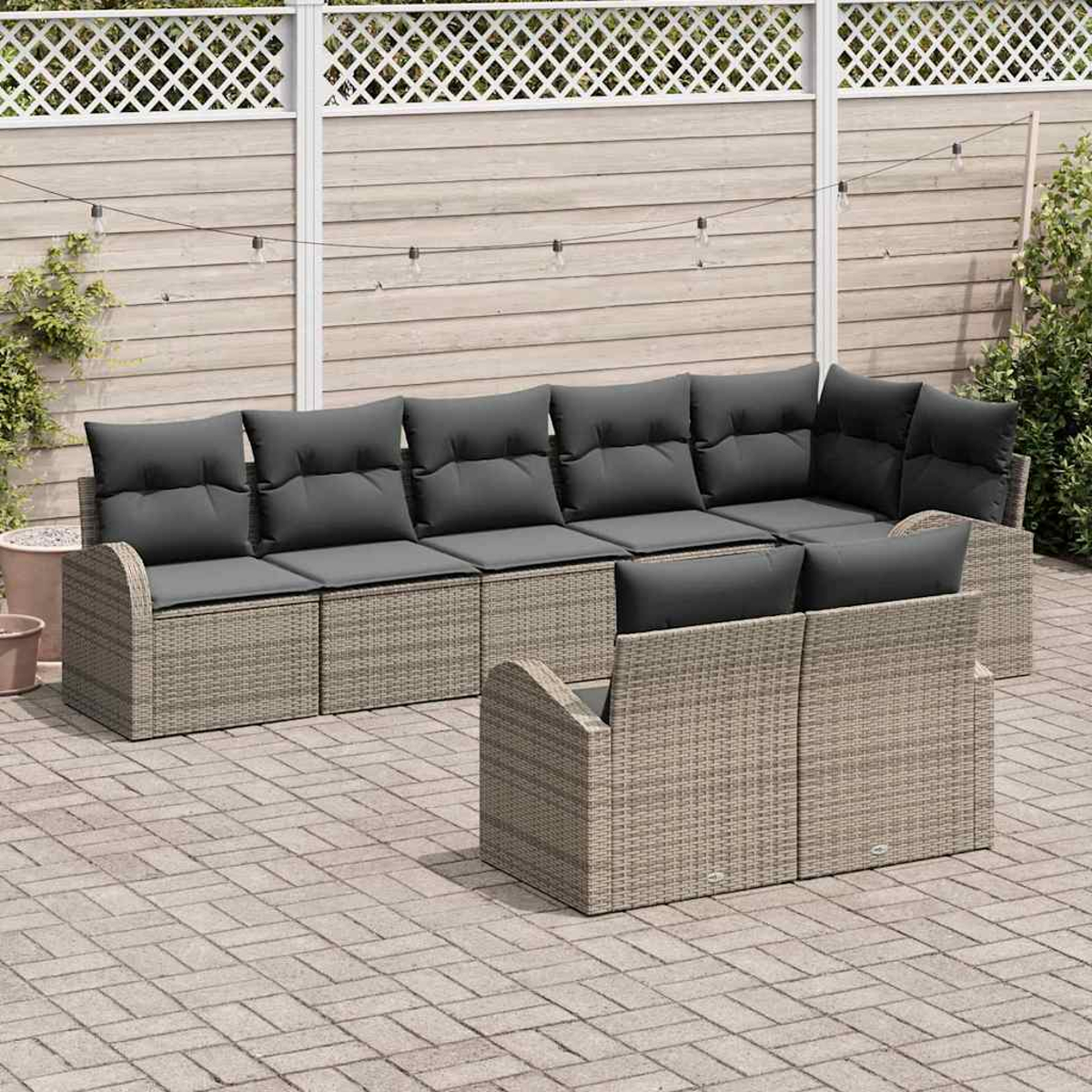 Garten-Terrassenset mit grauen Kissen. Ein großes Ecksofa und ein kleineres Liebesofa befinden sich auf einer Ziegelterrasse mit Zaun im Hintergrund.