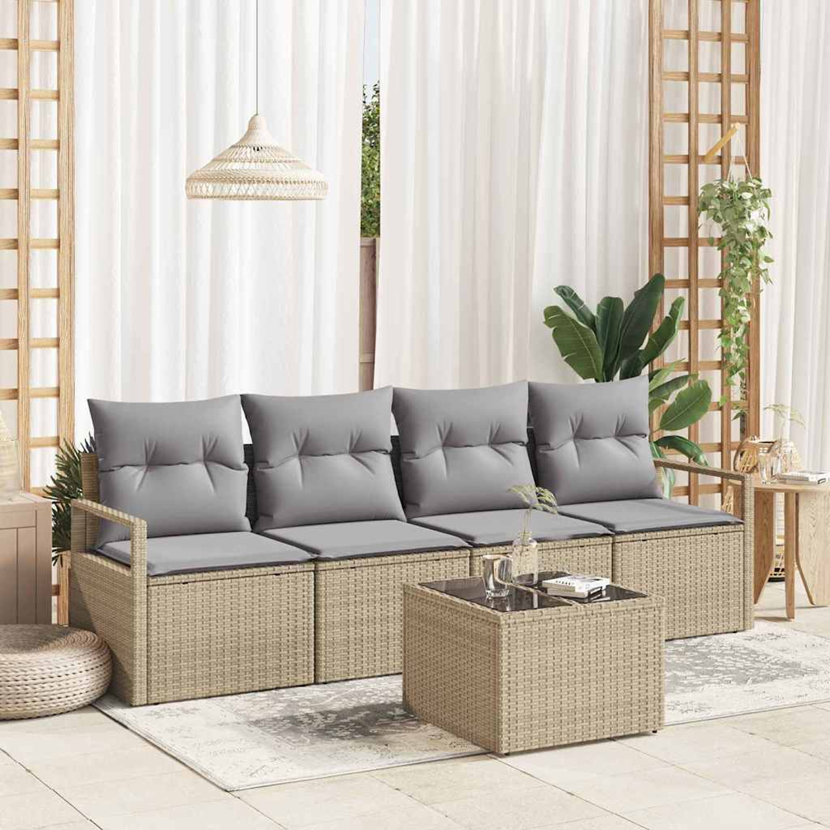 Gartenmöbel mit grauen Kissen, Rattanmöbeln und einem Tisch mit Glasplatte. Vorhänge und Pflanzen im Hintergrund.