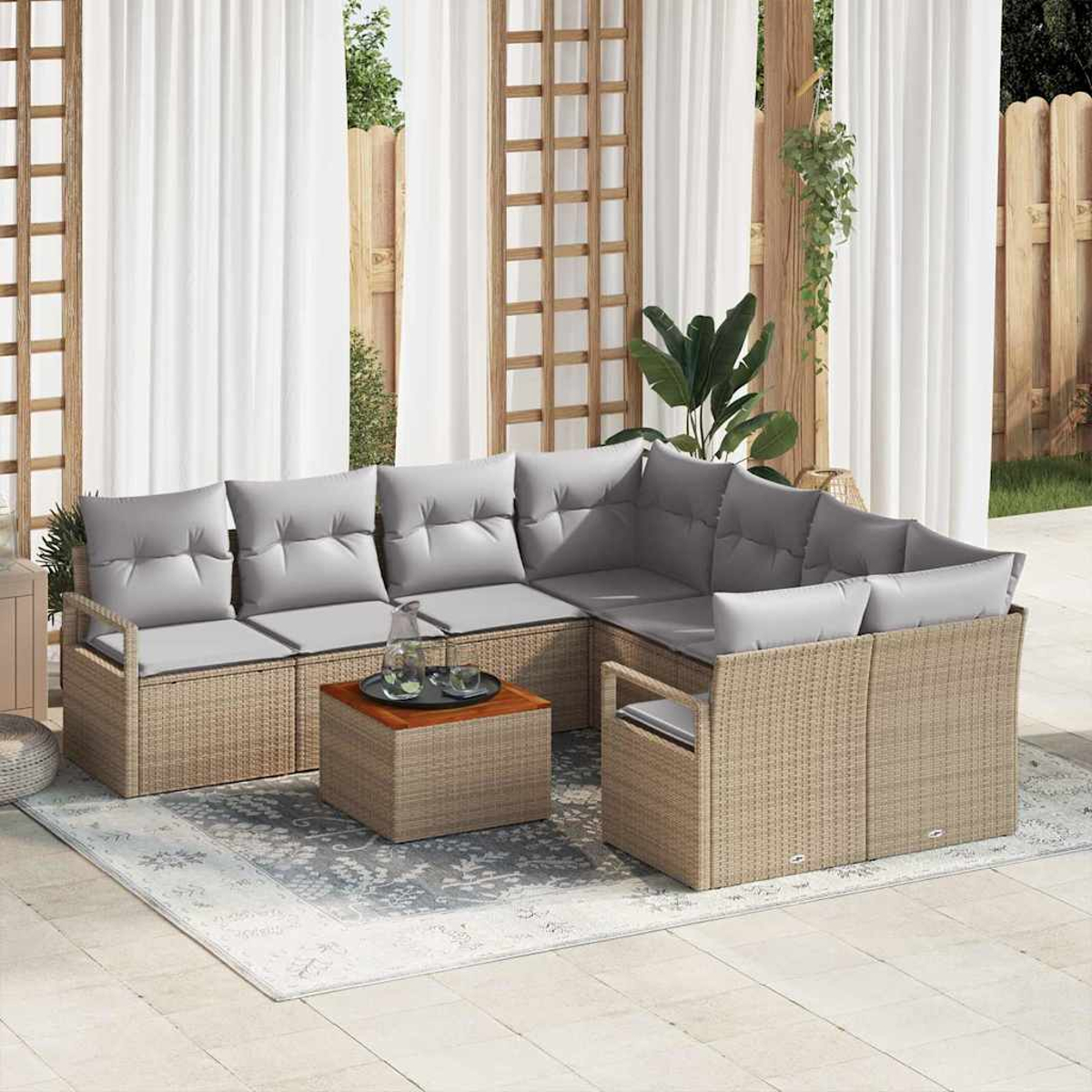 Outdoor-Ecksofa mit grauen Kissen, einem kleinen Tisch mit Tablett und einem Teppich. Weiße Vorhänge und ein Holzzaun befinden sich im Hintergrund.