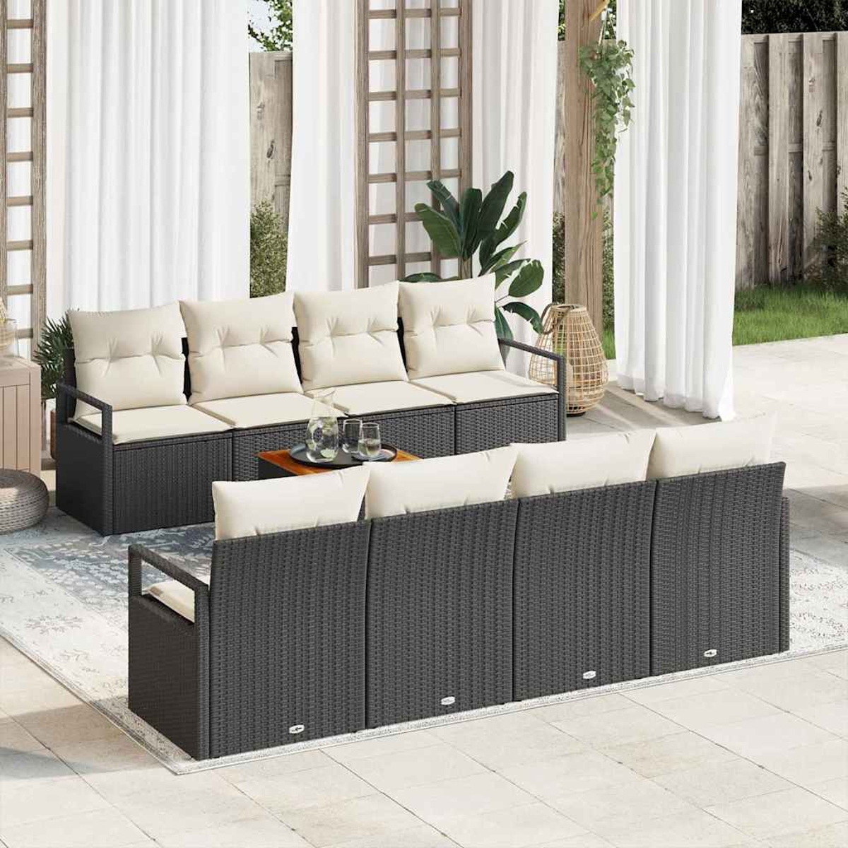 Terrassen-Set mit grauen Korbs Sofas, beigen Kissen und einem kleinen Holztisch, weißen Vorhängen und einem Teppich.