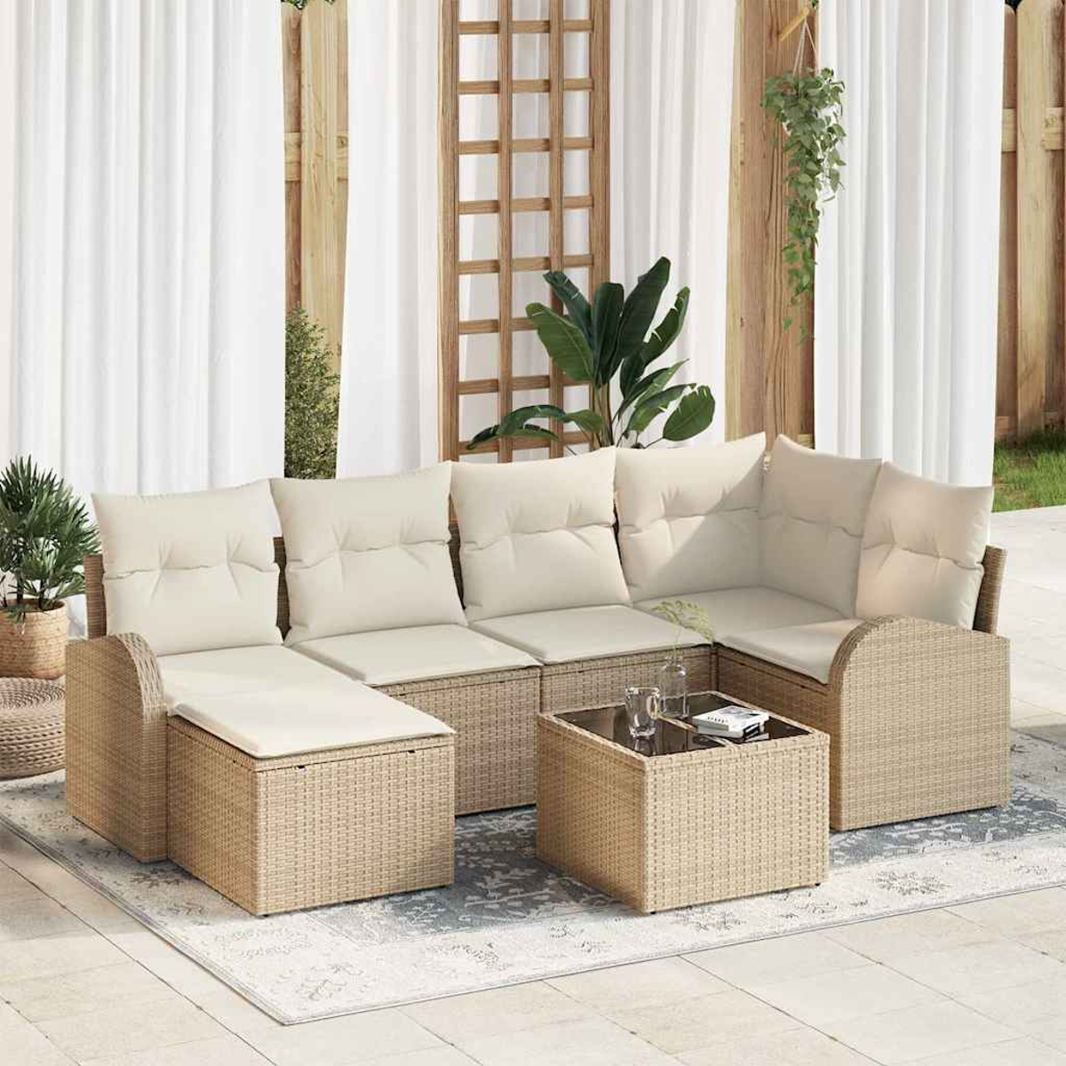 Garten-Sitzgruppe mit beigen Kissen, Couchtisch und Pflanzen. Weiße Vorhänge und Holzgitter im Hintergrund.
