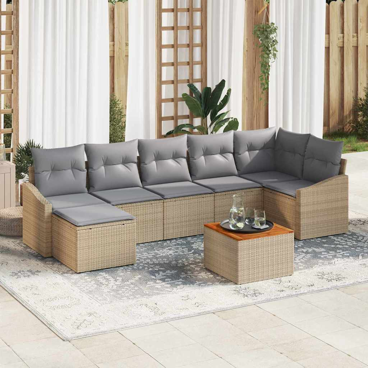Outdoor-Ecksofa mit grauen Kissen. Ein kleiner Tisch mit Getränken steht auf einem Teppich. Weiße Vorhänge und Holzzaun im Hintergrund.