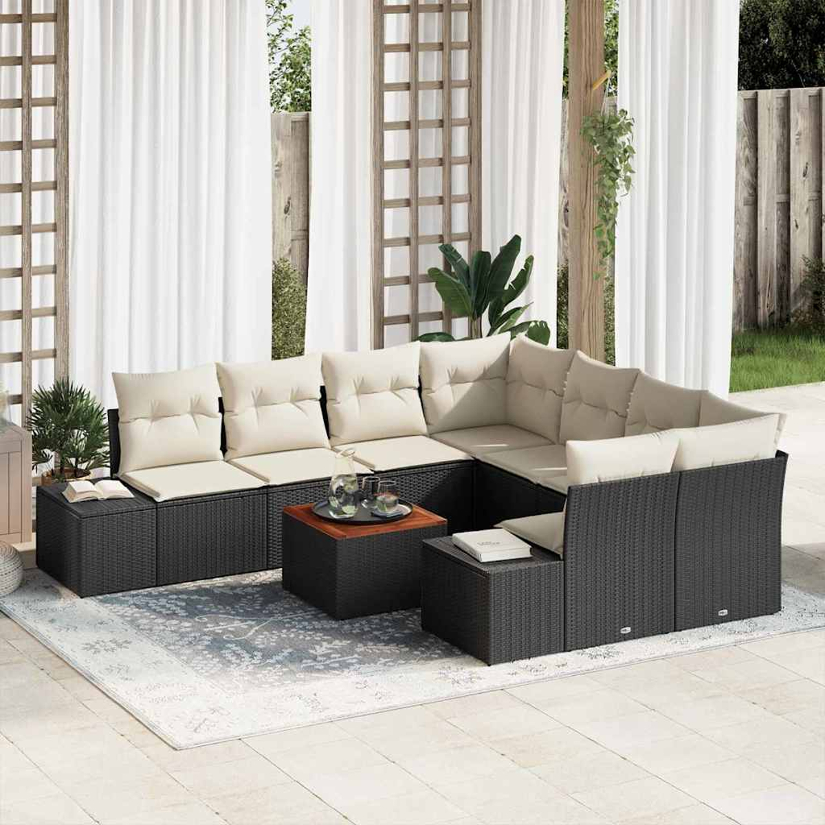 Outdoor-Ecksofa mit cremefarbenen Kissen, schwarzem Webrahmen und Beistelltisch aus Holz. Weiße Vorhänge und ein gemusterter Teppich.