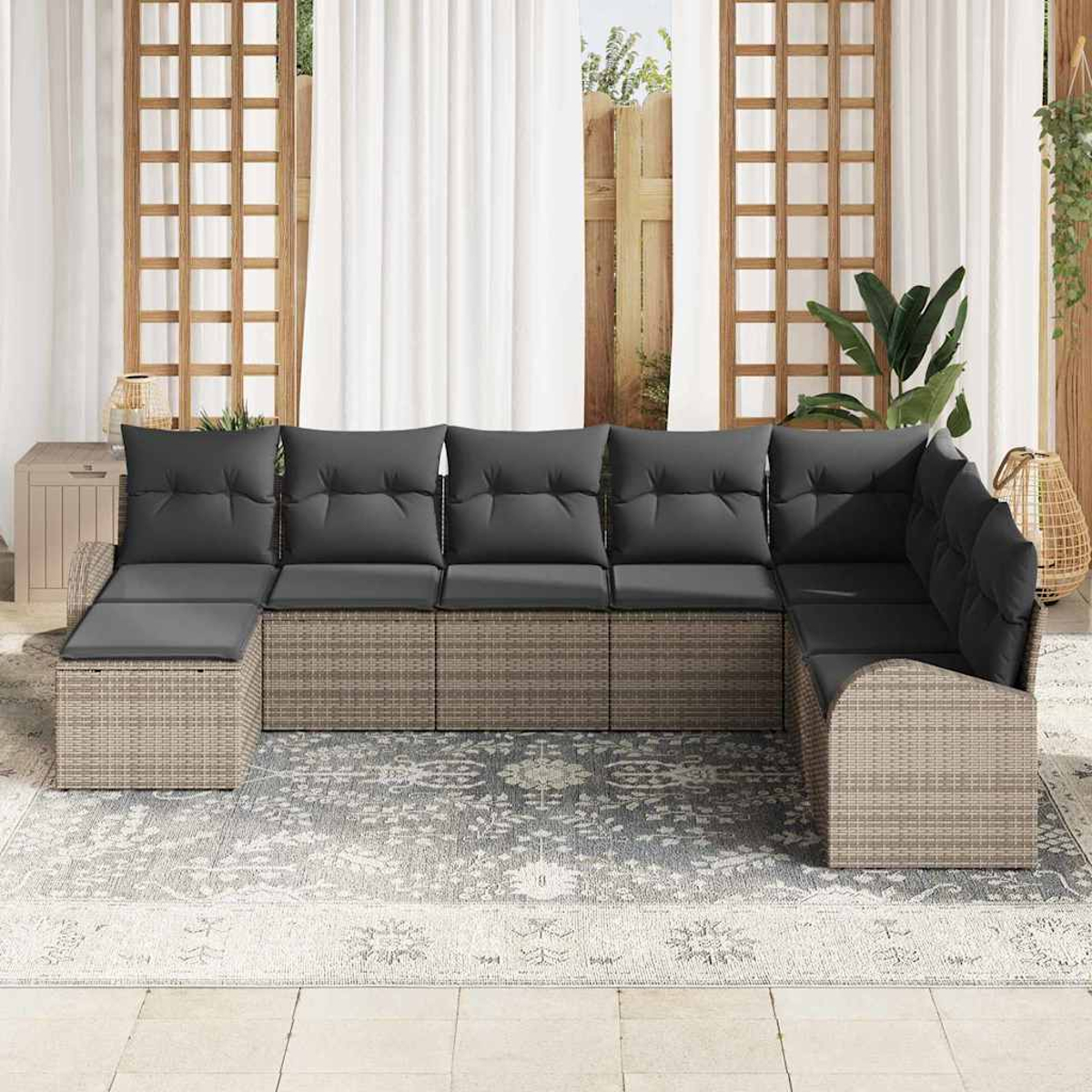 Ein modernes Ecksofa mit grauen Kissen steht auf einem gemusterten Teppich. Der Hintergrund umfasst Fenster und Pflanzen.