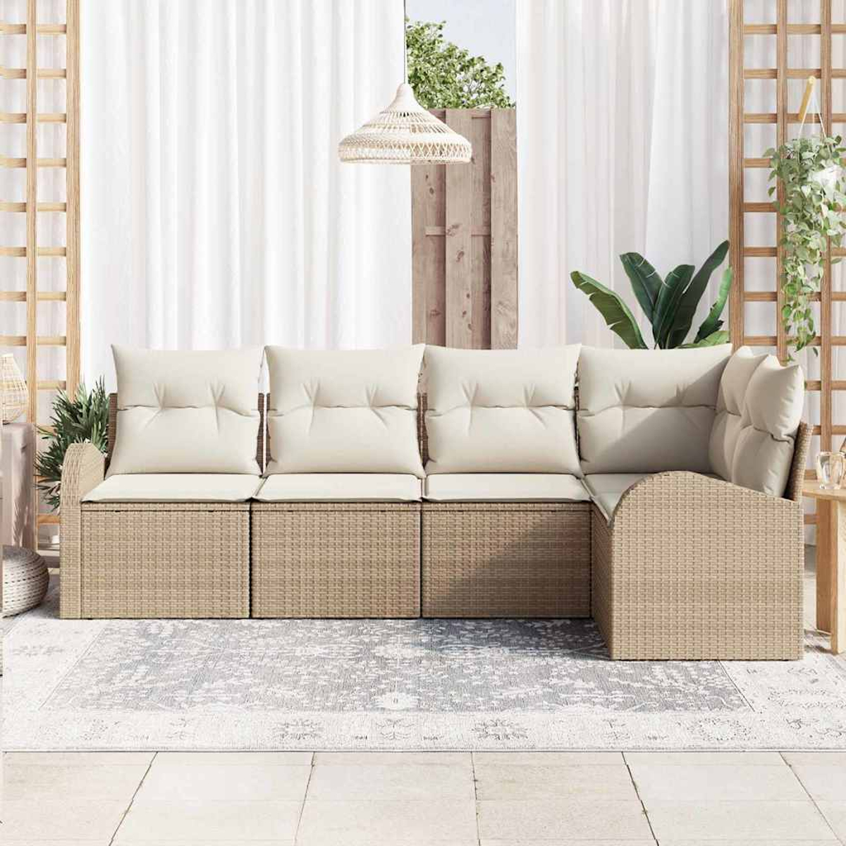 Ein beiges Ecksofa aus Korbgeflecht mit cremefarbenen Kissen steht auf einem gemusterten Teppich. Über dem Sofa hängt eine gewebte Leuchte.