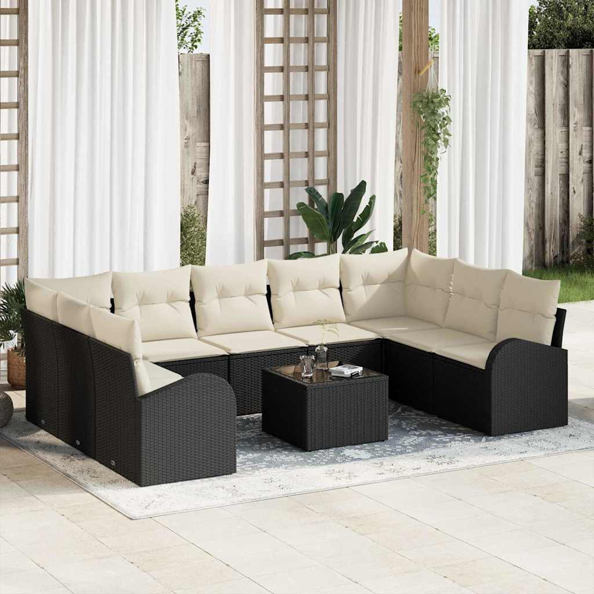 Outdoor-Ecksofa mit beigen Kissen und schwarzem Korbgewebe, quadratischer Couchtisch, auf einer Terrasse mit weißen Vorhängen im Hintergrund.