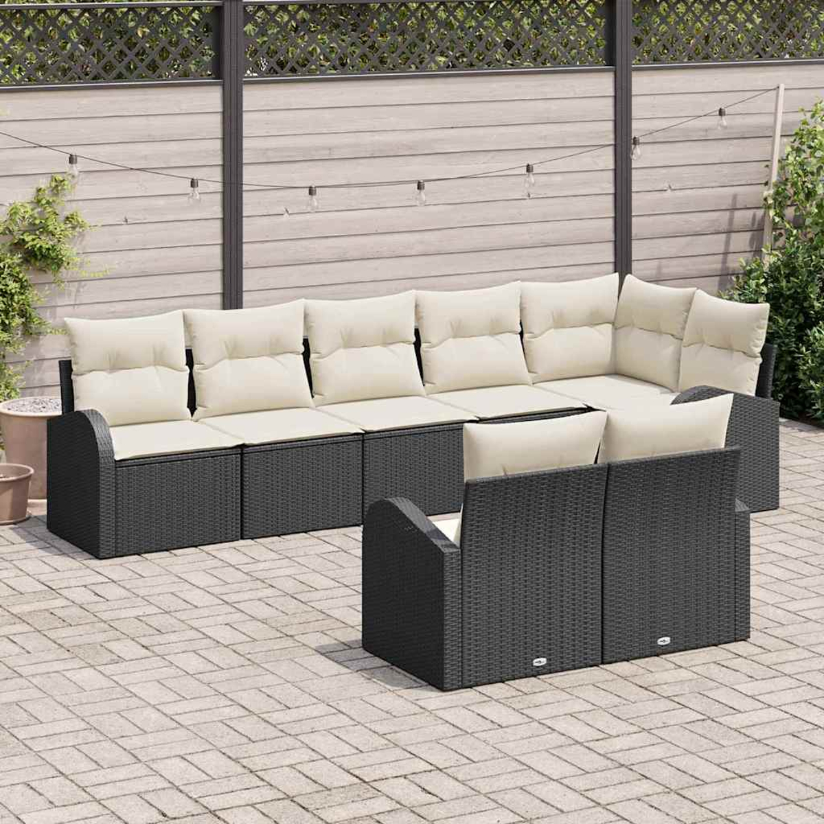 Gartenmöbel-Set. Dunkelgraues Korbgeflecht mit cremefarbenen Kissen. Auf einer Backstein-Terrasse mit Holzzaun im Hintergrund.