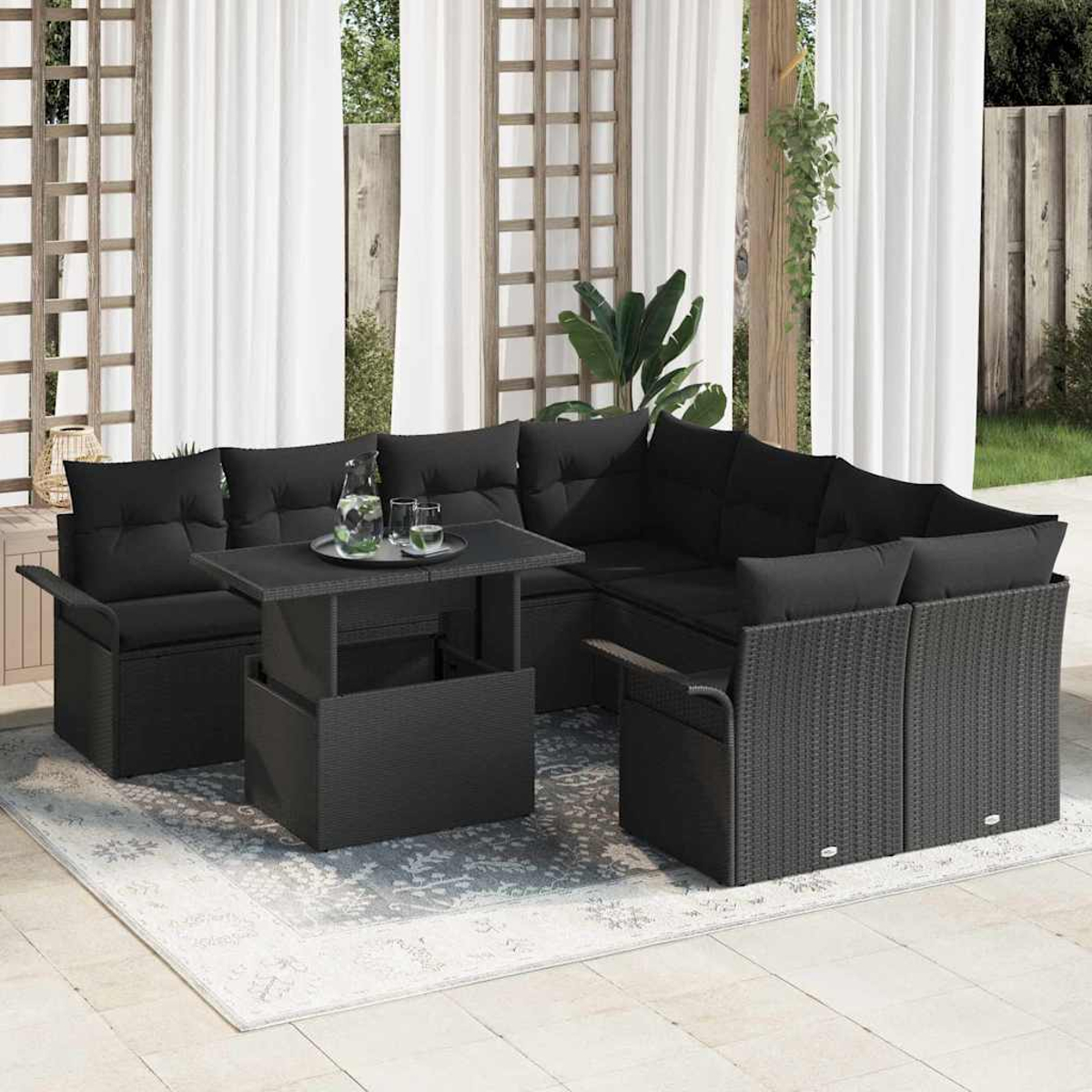 Schwarzes Outdoor-Geflecht-Ecksofa mit einem Tisch mit Hubfunktion. Ein Tablett mit Gläsern und eine Wasserkrug stehen auf dem Tisch.
