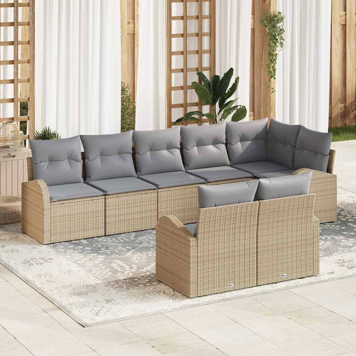 Outdoor-Sofa aus Korbgeflecht mit grauen Kissen auf einer Terrasse. Weiße Vorhänge und Holzgitter im Hintergrund, mit Pflanzen.