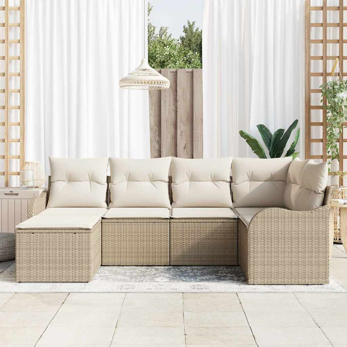 Geflochtenes Outdoor-Ecksofa mit cremefarbenen Kissen. Weiße Vorhänge und ein Holzgitter im Hintergrund.