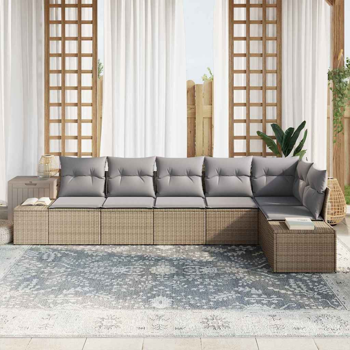 Sofá seccional exterior con cojines grises sobre una alfombra estampada. Cortinas blancas y enrejado de madera al fondo.