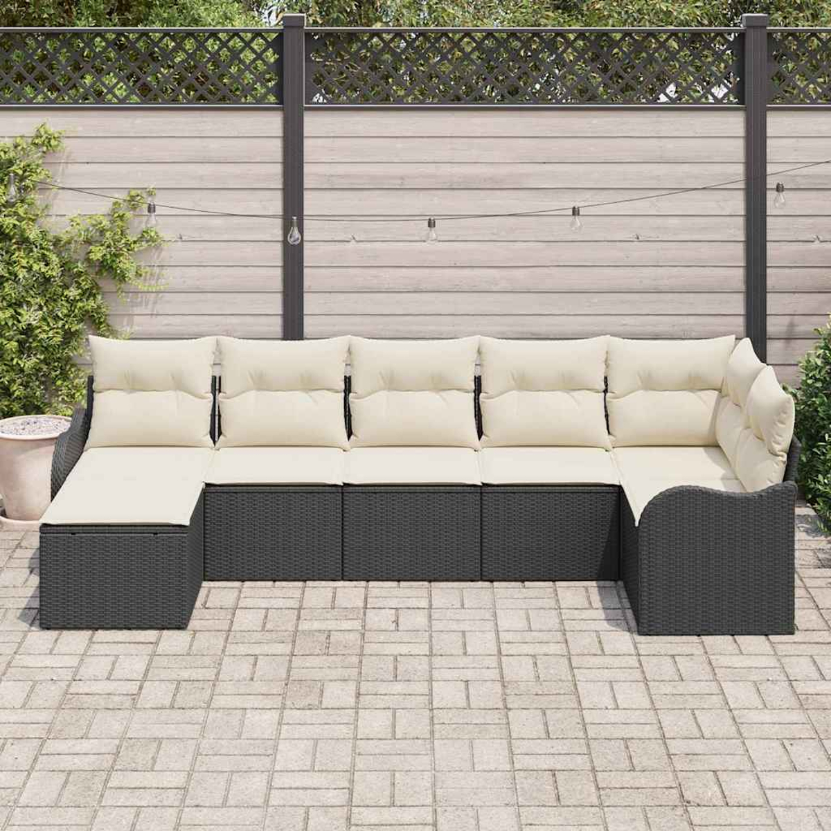 Outdoor-Ecksofa mit beigefarbenen Kissen und dunkelgrauer Korbbasis auf einer Terrasse. Zaun und Grün im Hintergrund.