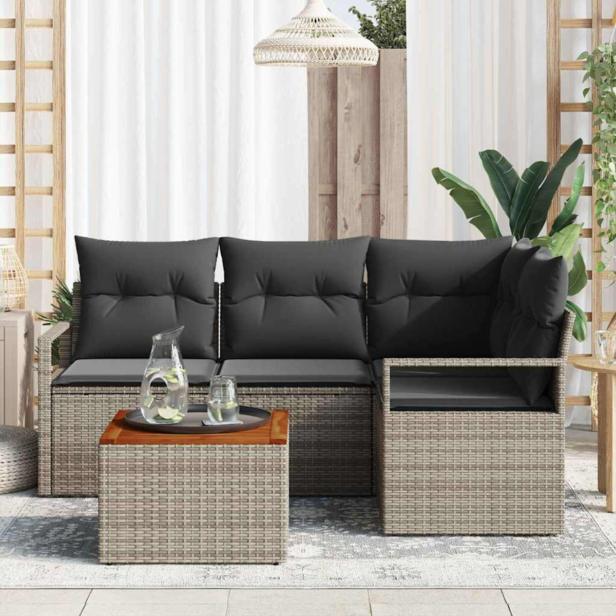 Outdoor-Ecksofa mit grauen Kissen, einem Holztisch mit Wasser und Gläsern sowie einer gewebten Leuchte.