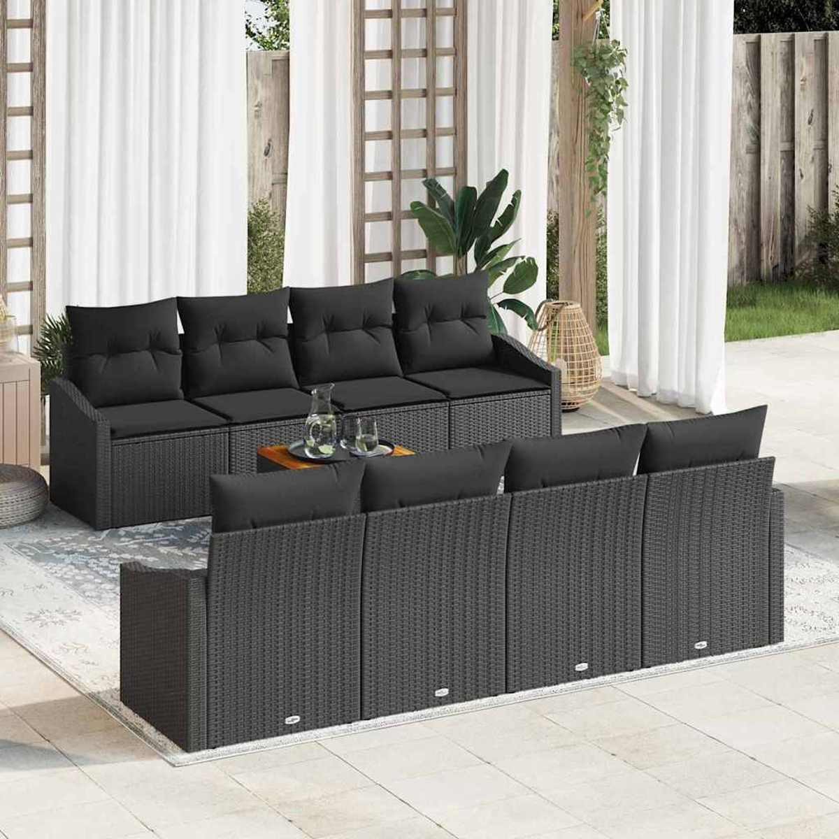 Terrassenset mit schwarzen Kissen. Enthält ein Sofa, einen Couchtisch mit Getränken und Vorhänge im Hintergrund.