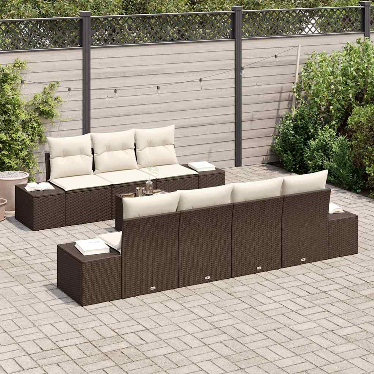 Gartenmöbel-Set mit braunen Korbgeweben und cremefarbenen Kissen auf einer Steinterrasse mit Zaun im Hintergrund.