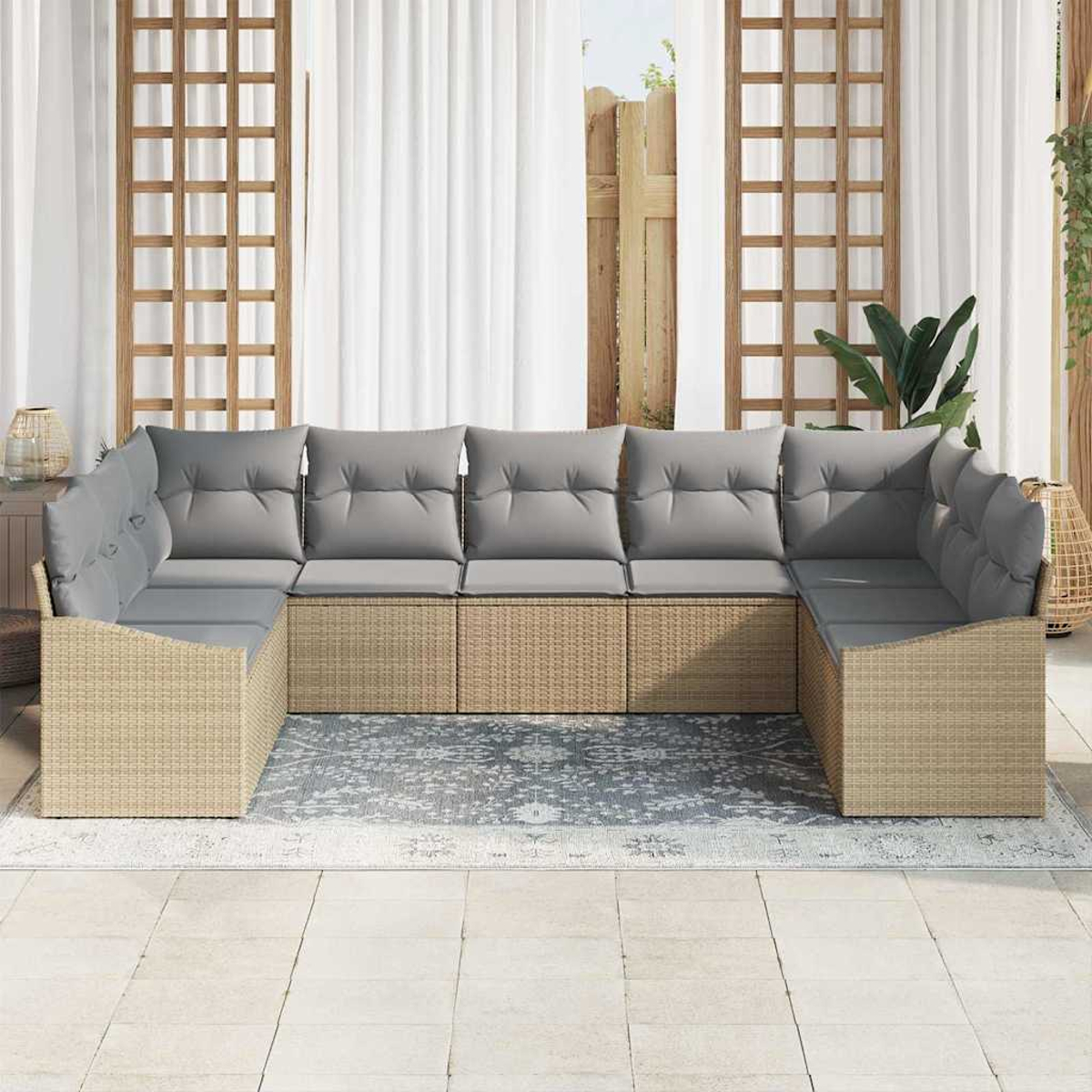 Ein U-förmiges Outdoor-Sofa mit grauen Kissen steht auf einem Teppich. Der Hintergrund umfasst weiße Vorhänge, Holzgitter und Pflanzen.