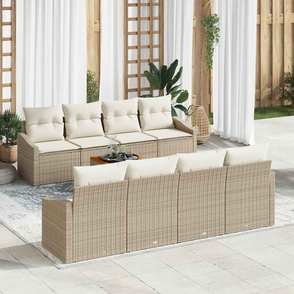Terrassenset mit beigefarbenen Korbsesseln, cremefarbenen Kissen und einem kleinen Tisch. Weiße Vorhänge und Holzzaun im Hintergrund.