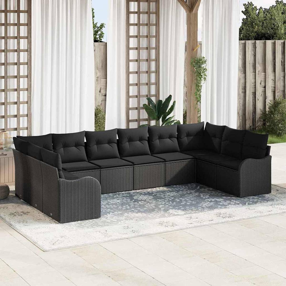 Ein schwarzes Outdoor-Ecksofa mit Kissen steht auf einem Teppich vor weißen Vorhängen und einer Holzkonstruktion.