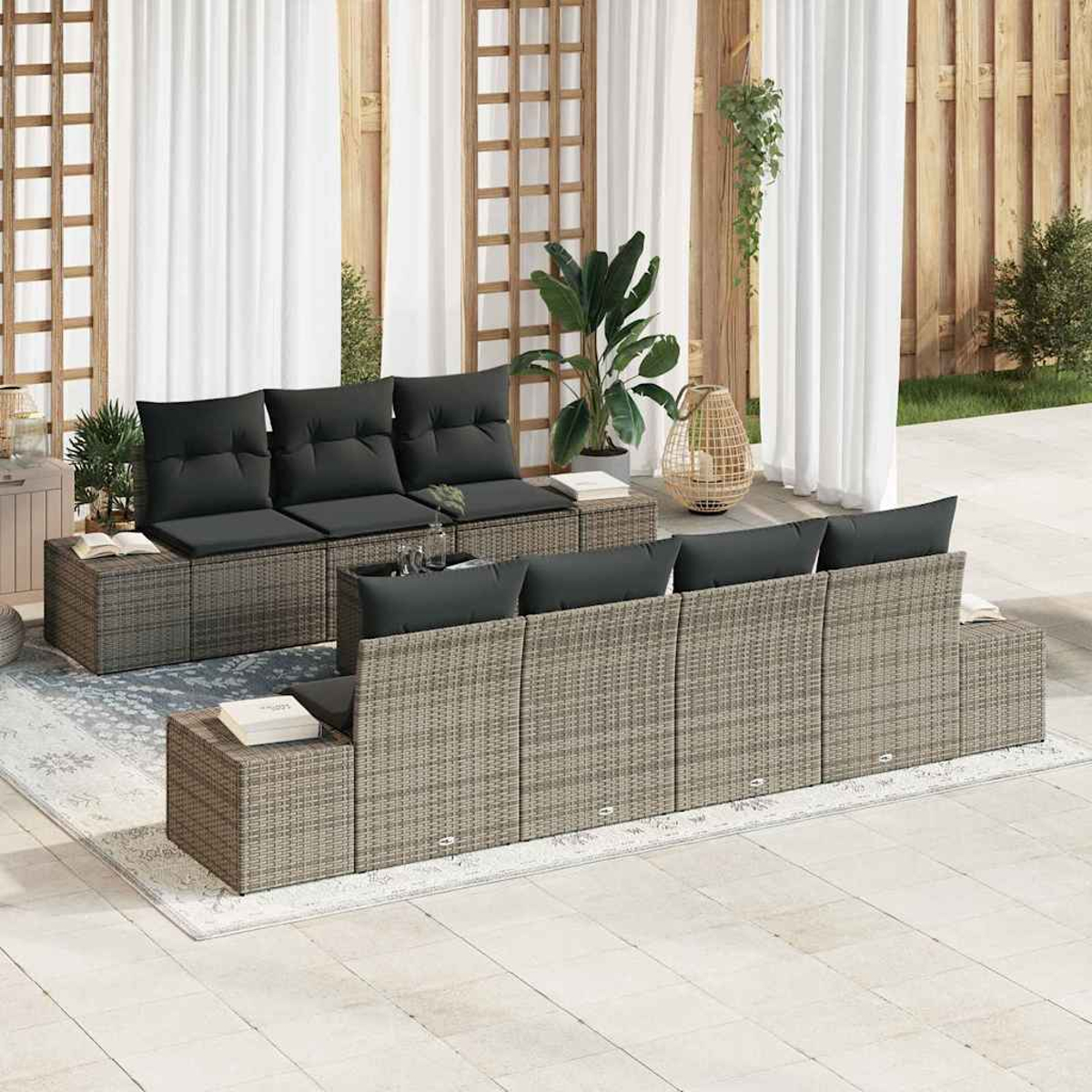 Terrasse mit Korbmöbeln, schwarzen Kissen, Pflanzen und weißen Vorhängen. Ein entspannender Außenbereich.