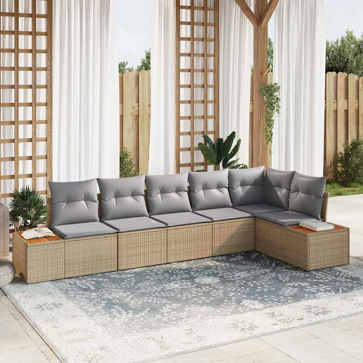 Outdoor-Ecksofa mit grauen Kissen auf einem gemusterten Teppich. Weiße Vorhänge, Holzgitter und Holzzaun im Hintergrund.
