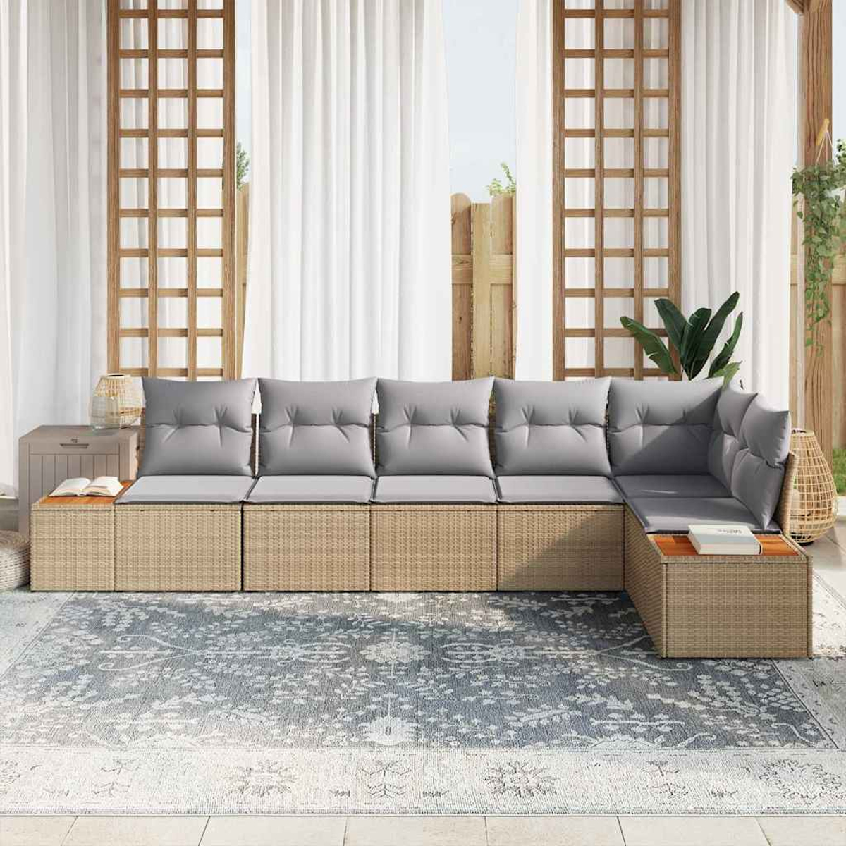 Ein Ecksofa im Freien mit grauen Kissen. Es steht auf einem gemusterten Teppich, dahinter Vorhänge und ein Holzgitter.