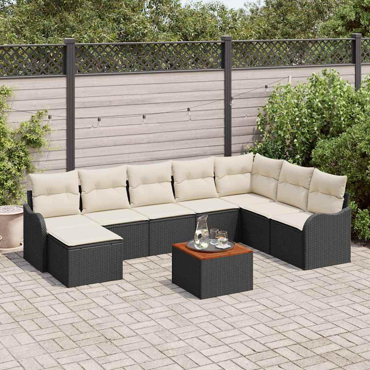 Outdoor-Ecksofa mit cremefarbenen Kissen, einem Holztisch und einem Zaunhintergrund mit Grün auf einer Ziegelterrasse.