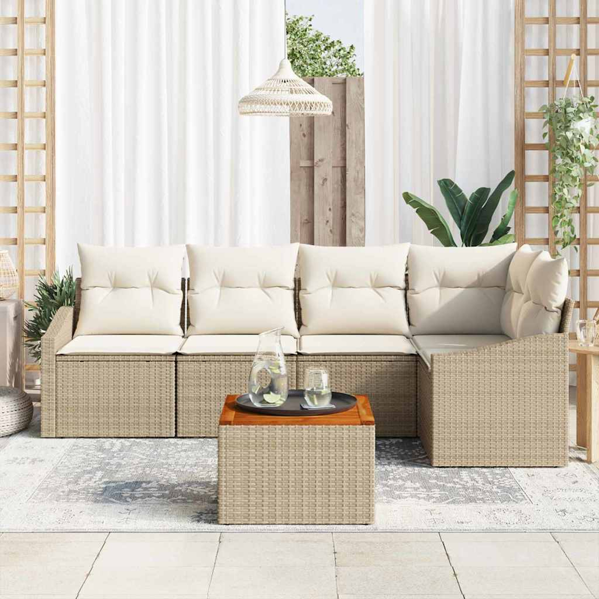 Szene im Freien mit Rattansofa, Couchtisch und Kissen. Weiße Vorhänge, Pflanzen und eine Hängelampe. Neutrale Farben.