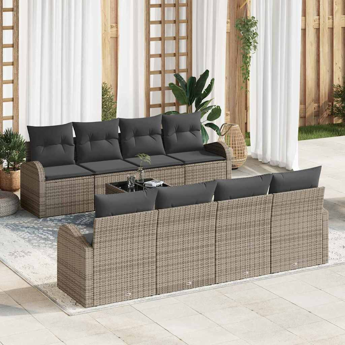 Outdoor-Geflechtmöbel-Set mit grauen Kissen. Enthält ein Sofa und Stühle. Der Hintergrund hat Vorhänge, Pflanzen und Holzpaneele.