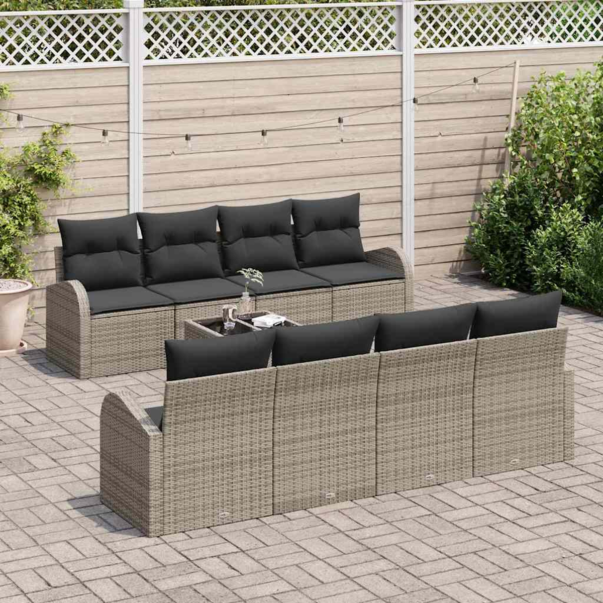 Gartenmöbel-Set mit grauen Kissen, einem kleinen Tisch und einem Holzzaun im Hintergrund.