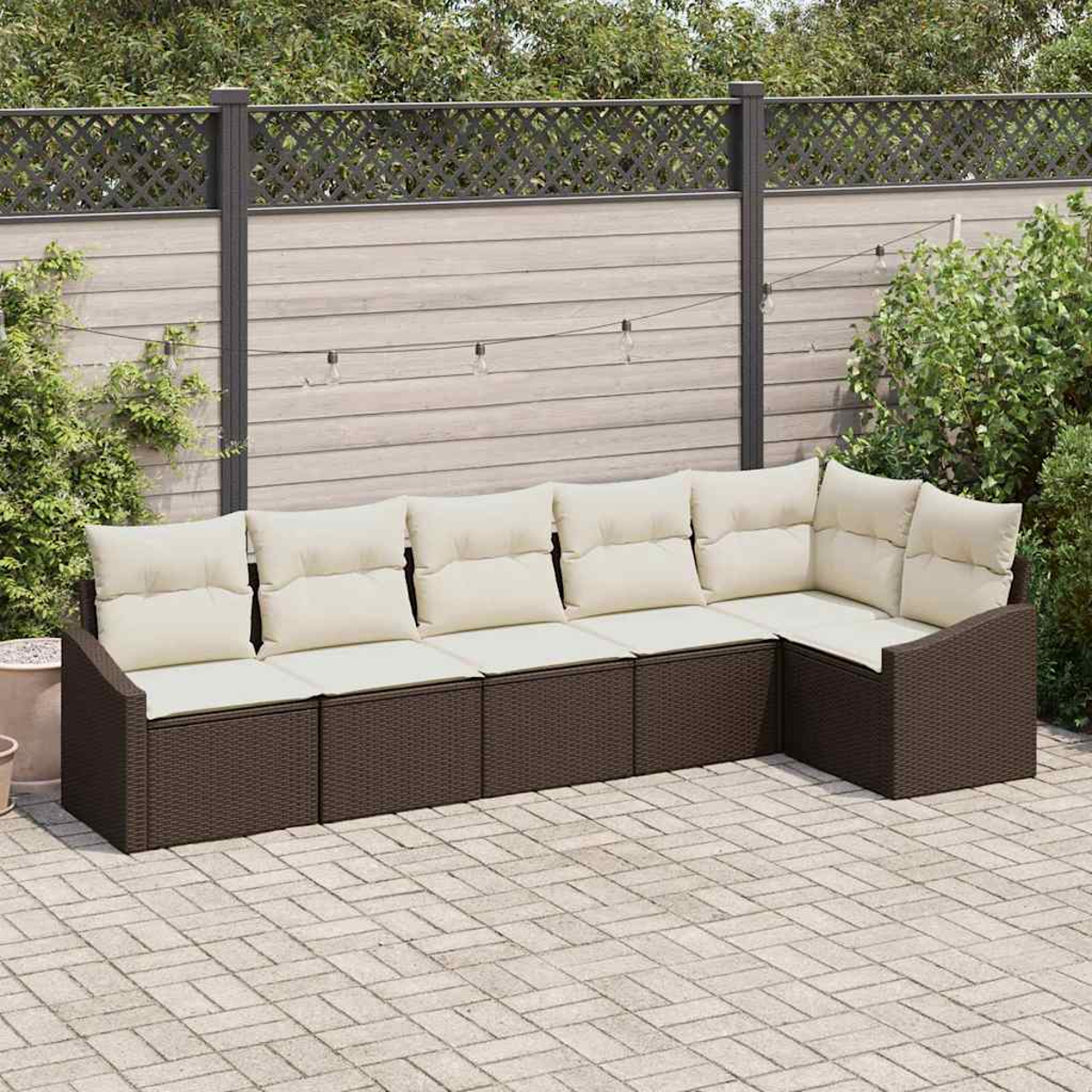 Ein Ecksofa mit cremefarbenen Kissen steht auf einer Terrasse. Im Hintergrund ein Holzzaun und Grün.