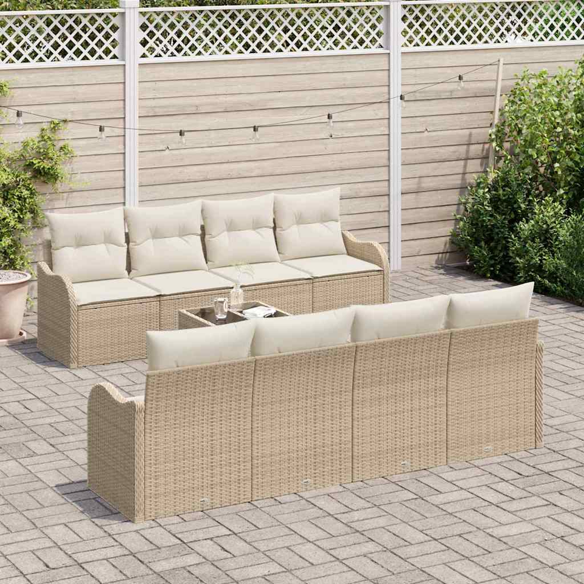 Rattansofa-Set im Freien mit beigefarbenen Kissen auf einer gepflasterten Terrasse. Vor dem Sofa steht ein kleiner Tisch mit Gläsern.