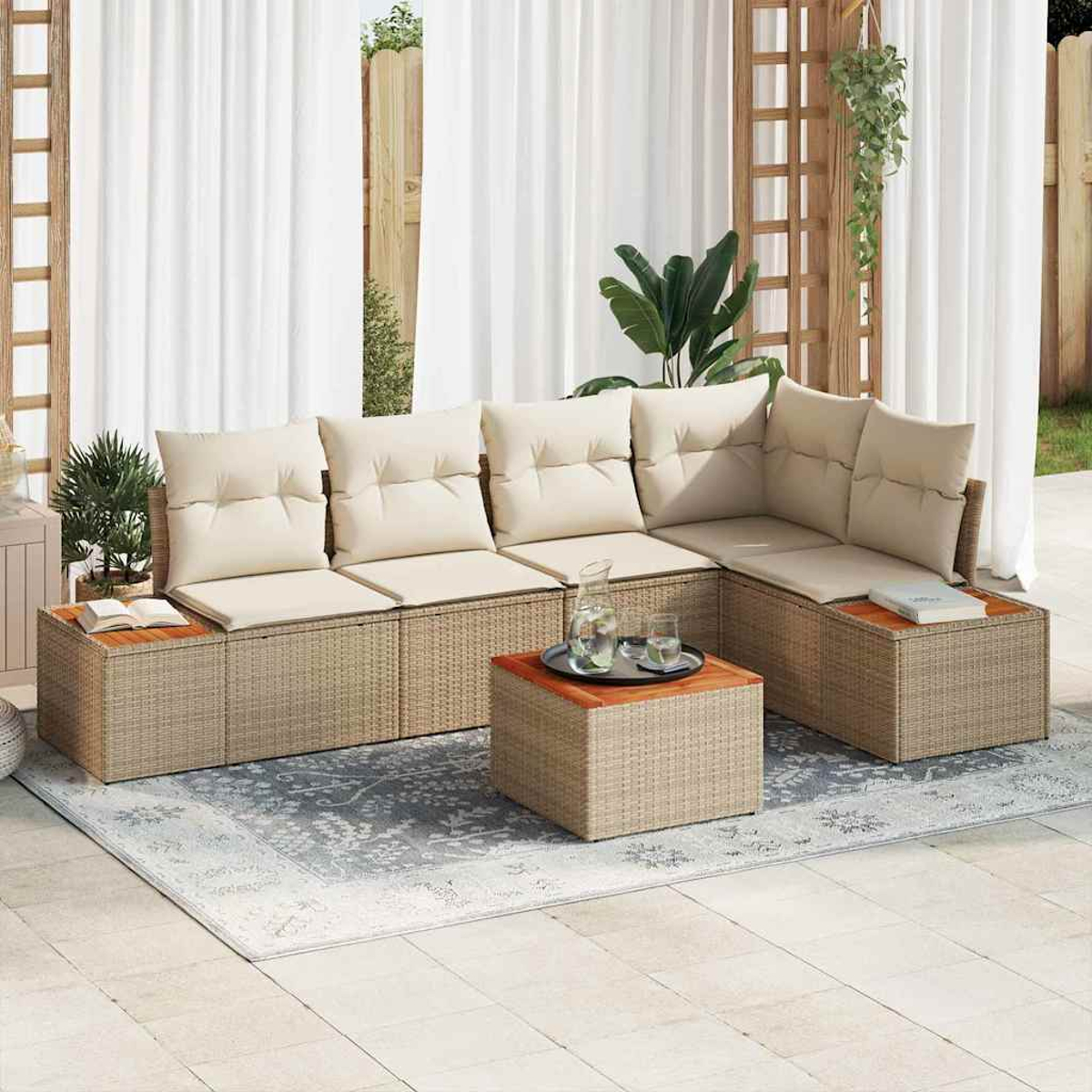 Zona de estar al aire libre con cojines beige, muebles de mimbre, una alfombra y una mesa pequeña con bebidas, todo bajo una cortina blanca.