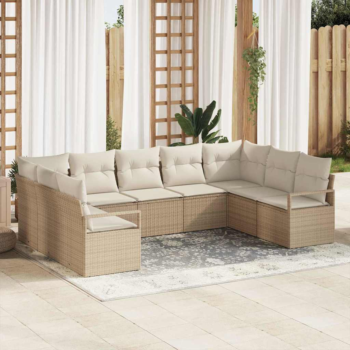 Ein beiges Ecksofa aus Korbgeflecht mit cremefarbenen Kissen steht auf einer Terrasse. Weiße Vorhänge und Holzgitter sind im Hintergrund.