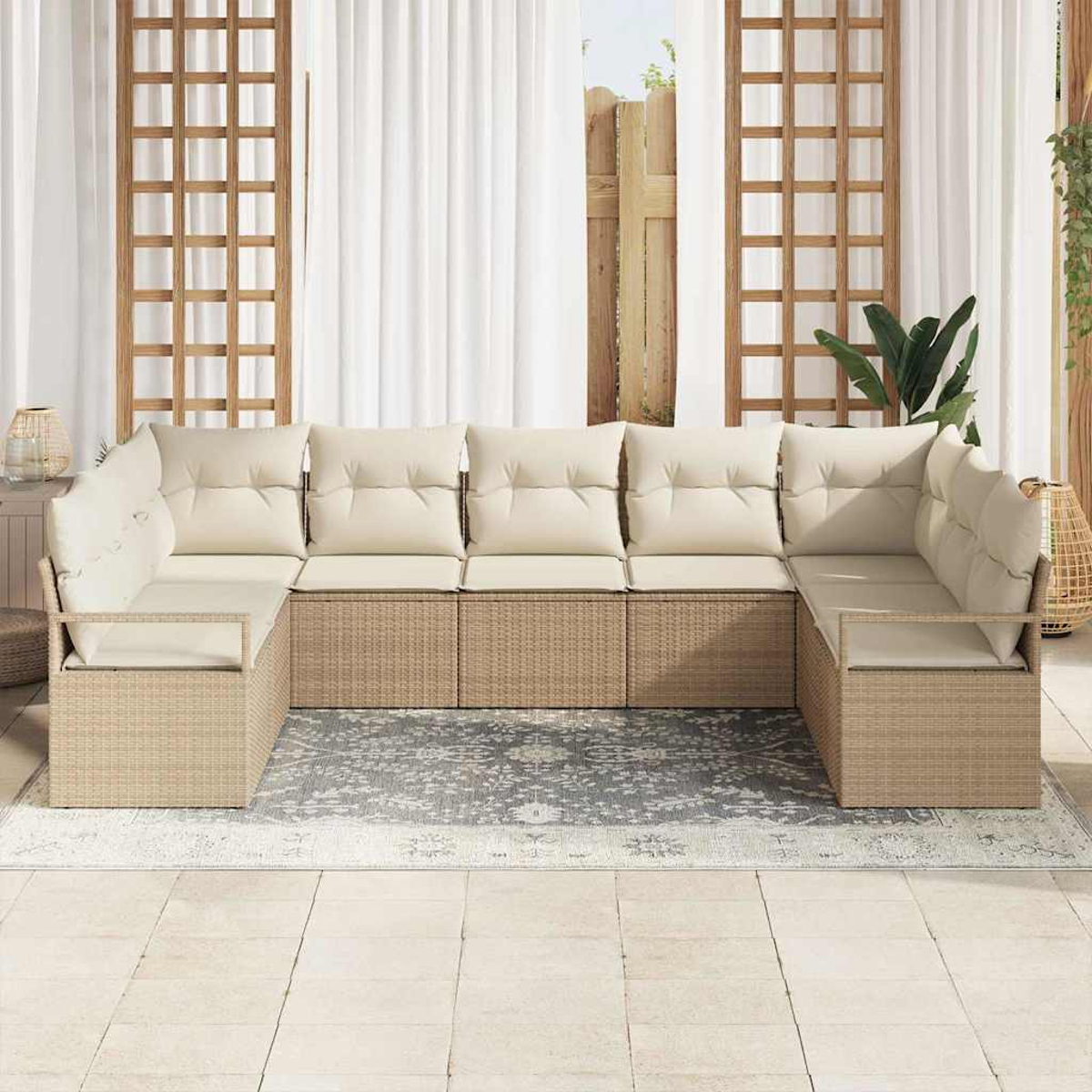 Ein beiges Korbsessel-Sofa mit cremefarbenen Kissen steht auf einem Teppich. Weiße Vorhänge und ein Holzgitter umrahmen die Szene.