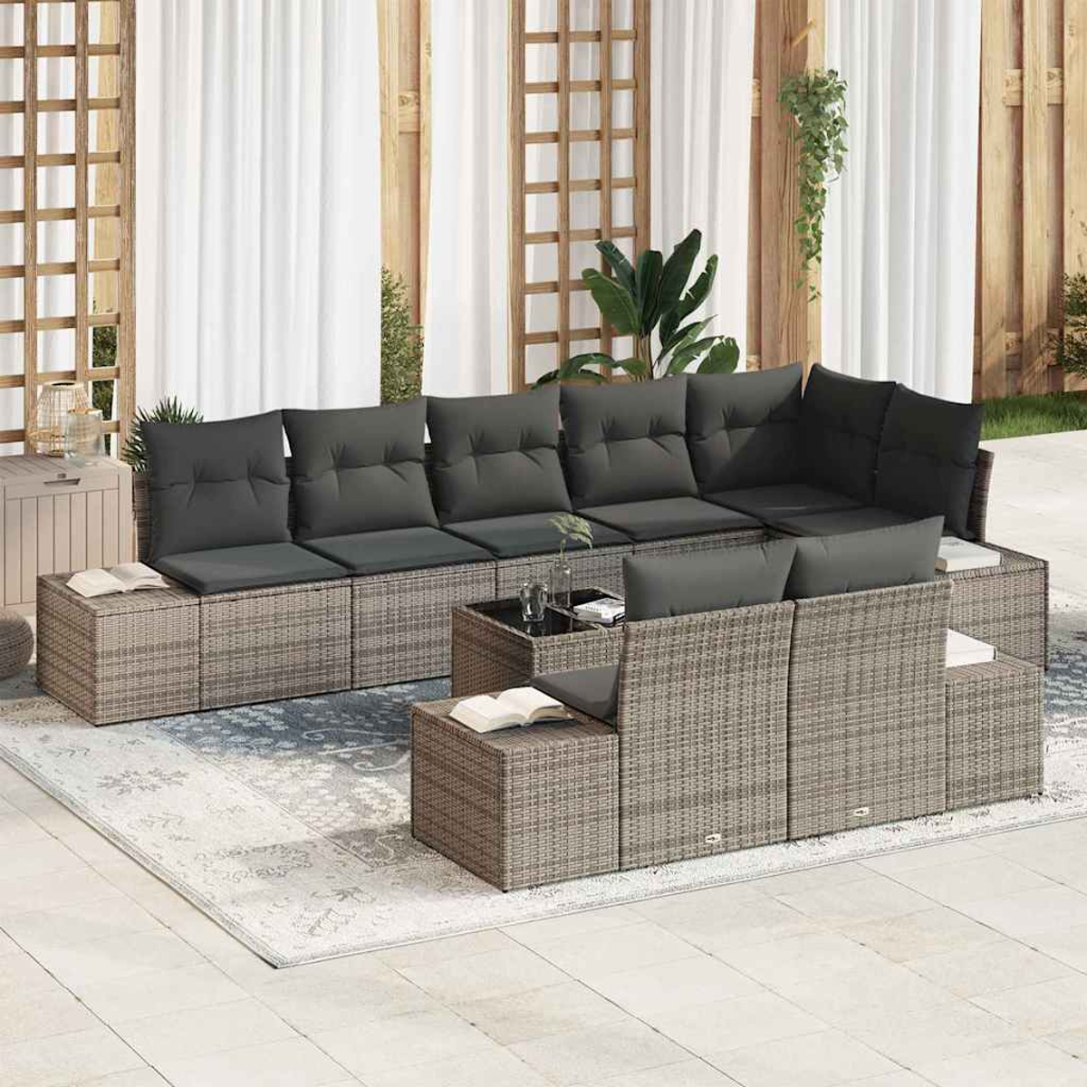 Outdoor-Ecksofa mit grauen Kissen auf einem gemusterten Teppich, Pflanzen und weißen Vorhängen im Hintergrund.