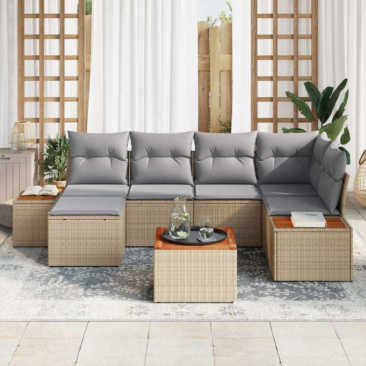 Outdoor-Ecksofa mit grauen Kissen, Rattansockel und hölzernen Beistelltischen. Auf einem Couchtisch stehen eine Glaskanne und ein Tablett.