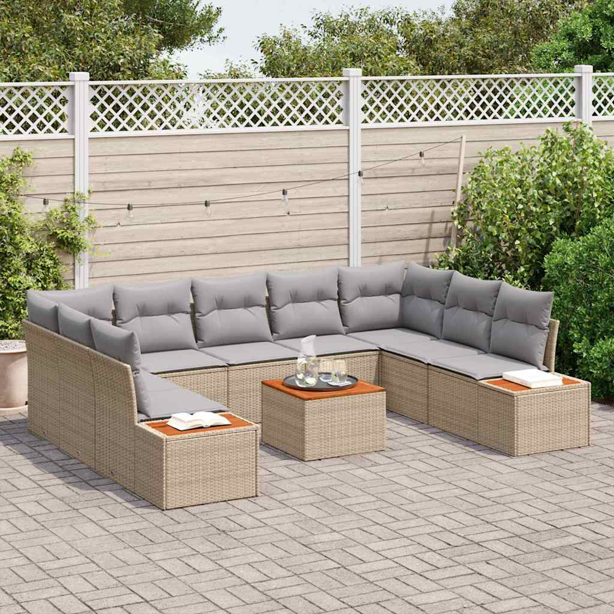 Outdoor-Ecksofa mit grauen Kissen und einem Couchtisch. Ein weißer Zaun und grüne Pflanzen befinden sich im Hintergrund auf einer gepflasterten Terrasse.