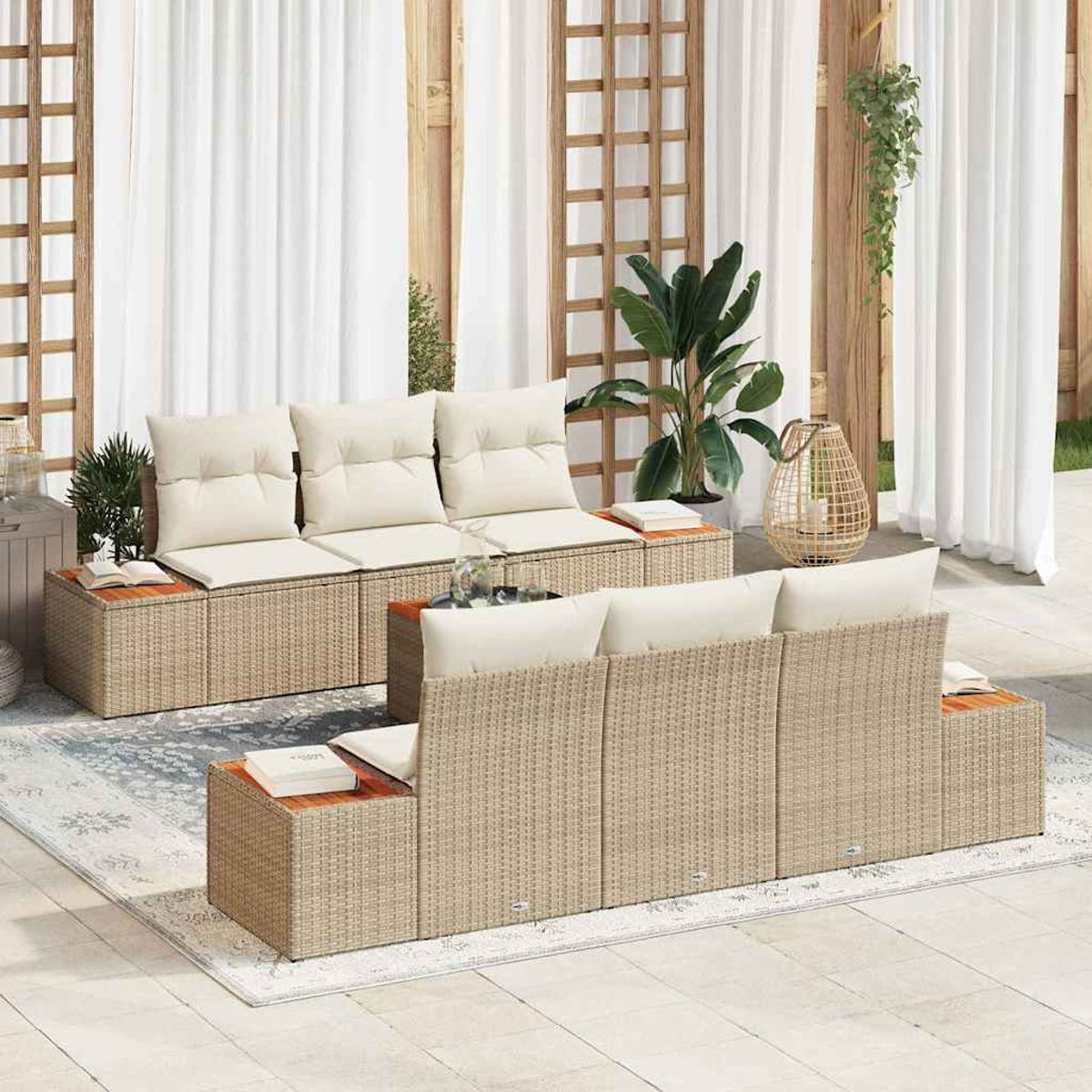 Outdoor-Sitzbereich mit Korbmöbeln, cremefarbenen Kissen, Holztischen und weißen Vorhängen. Ein Teppich, Pflanzen und eine Laterne vervollständigen die Szene.