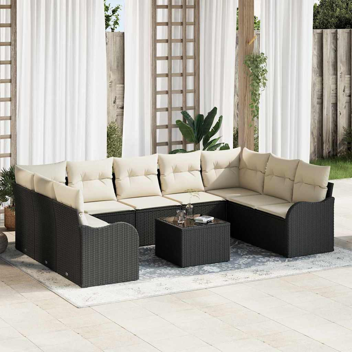 Outdoor-Ecksofa mit cremefarbenen Kissen auf einem gemusterten Teppich. Ein schwarzer quadratischer Couchtisch steht in der Mitte.