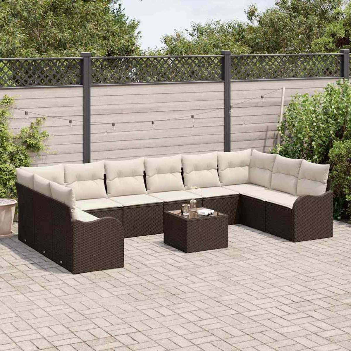 Ein braunes Outdoor-Ecksofa aus Korbgeflecht mit cremefarbenen Kissen und einem kleinen quadratischen Couchtisch.