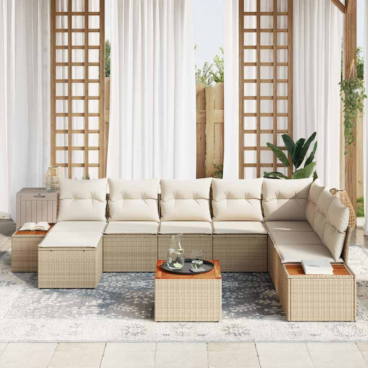 Outdoor-Ecksofa mit beigefarbenen Kissen, Rattansockel und hölzernen Beistelltischen. Weiße Vorhänge im Hintergrund. Teppich und Pflanzen.