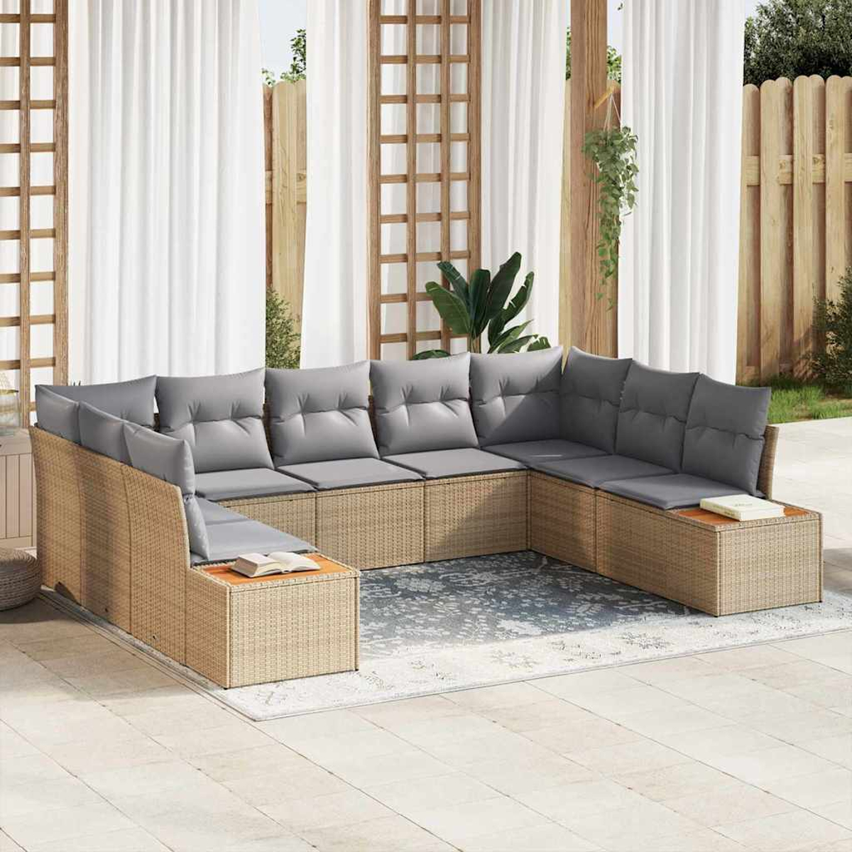 Ein Ecksofa aus Korbgeflecht mit grauen Kissen steht auf einer Terrasse. Weiße Vorhänge und ein Holzzaun sind im Hintergrund.