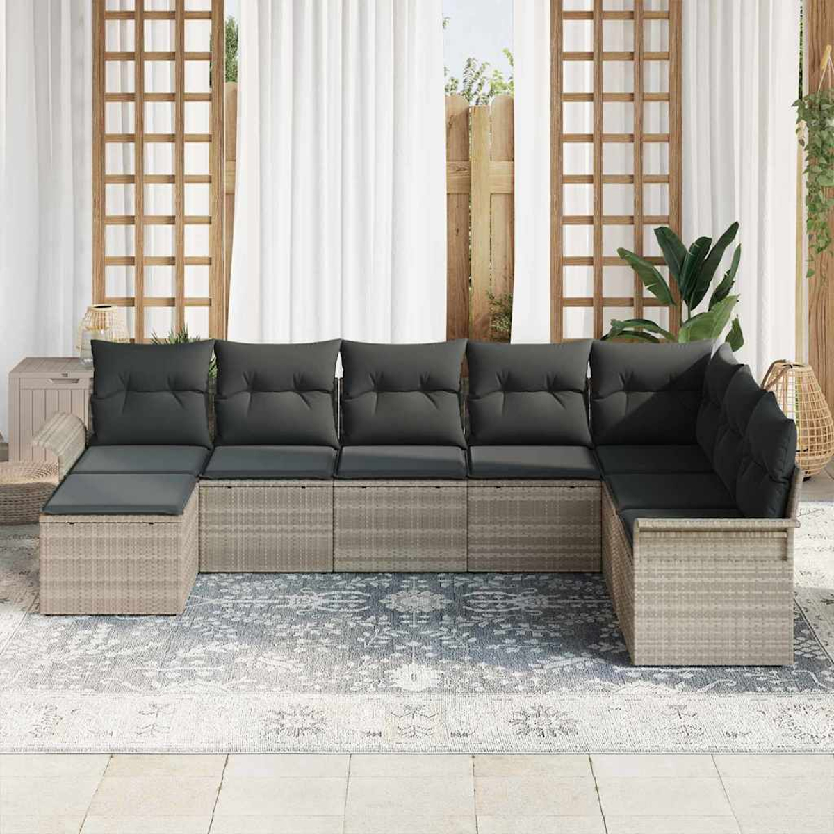 Outdoor-Ecksofa mit grauen Kissen auf einem Teppich. Dahinter sind weiße Vorhänge und Holzgitter zu sehen.