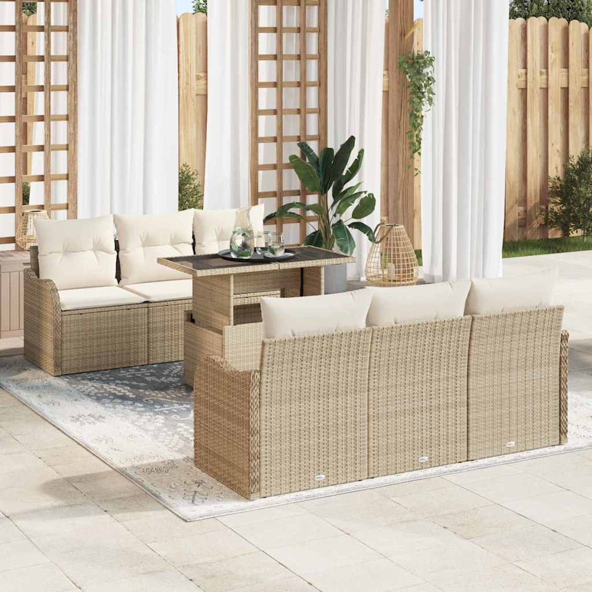 Garten-Rattanmöbel-Set, bestehend aus Sofa, Liebessitz und Tisch, auf einer Terrasse mit weißen Vorhängen und einem Teppich. Pflanzen und Dekor sind vorhanden.