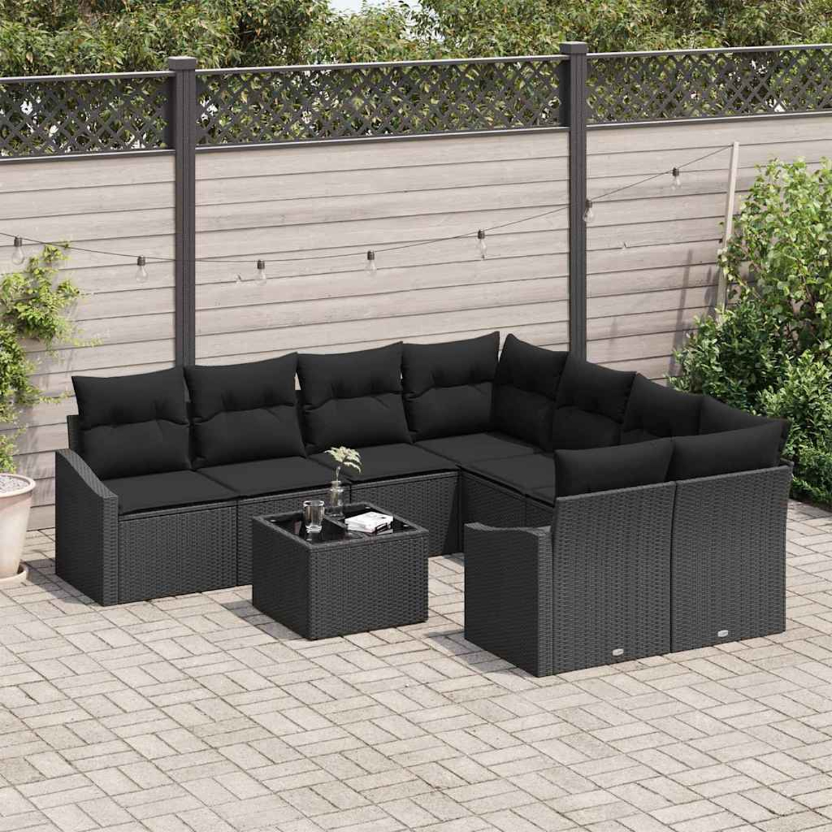 Juego de muebles de patio. Sofá seccional de mimbre negro, mesa de centro y sillas en patio de ladrillo. Fondo con valla y vegetación.